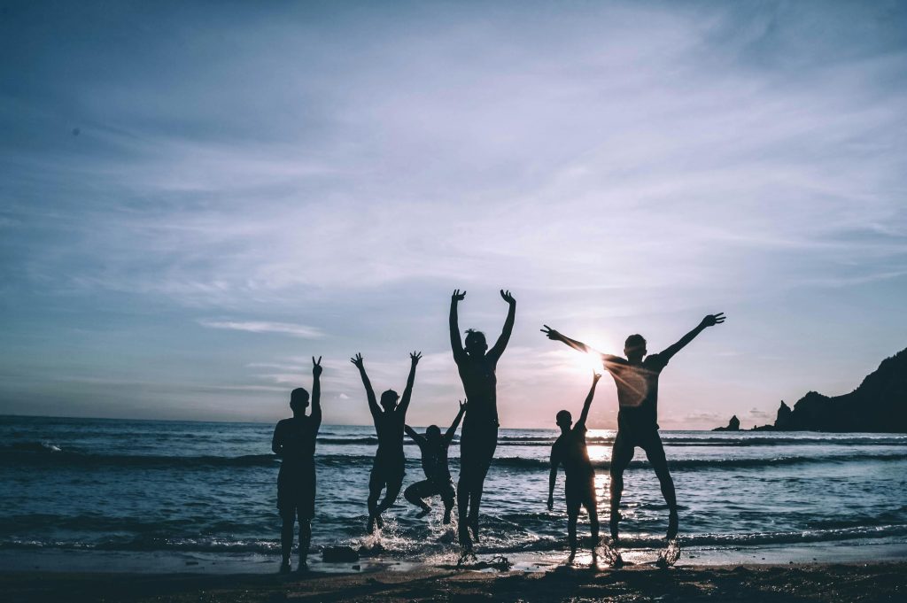 Gruppe von Freunden im Wasser bei Sonnenuntergang